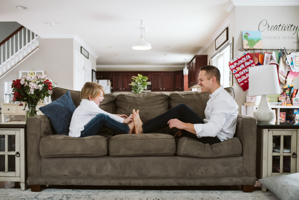 father and son playing on the sofa