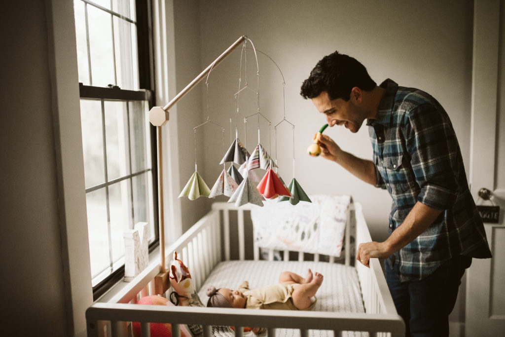 Father lookin at his daughter in her crib. Photo by Laura Mares Photography, Pittsburgh Lifestyle Photographer.