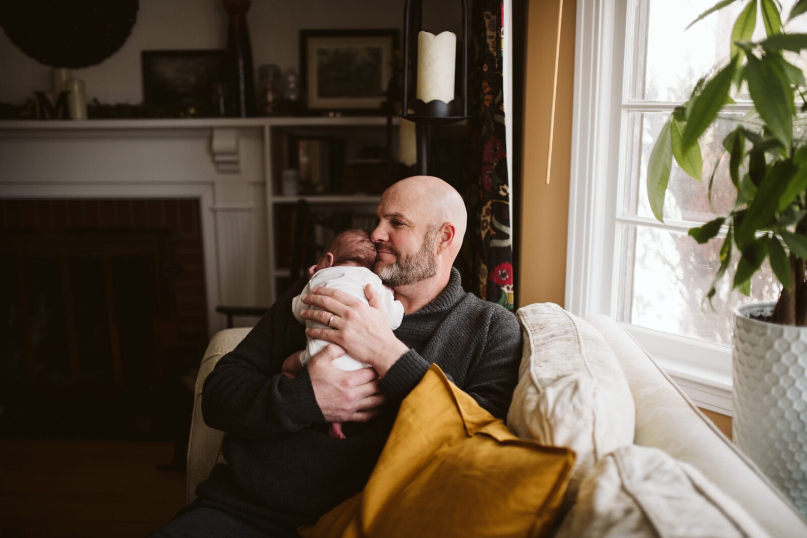 Father holding newborn baby at home. Portrait taken by Laura Mares Photography, Pittsburgh Newborn Photographer.