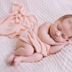 A newborn baby girl sleeping on her side. Photo by Laura Mares Photography, Pittsburgh Newborn Photographer.
