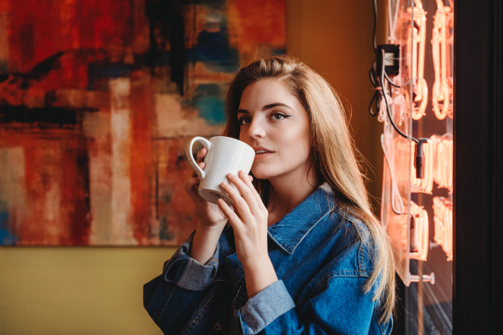 Photo of a high school senior girl drinking coffee at Uptown Coffee. Photo by Laura Mares Photography, Pittsburgh Senior Photographer.