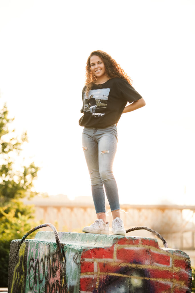 portrait of a high school senior girl standing in Pittsburgh's Color Park at sunset