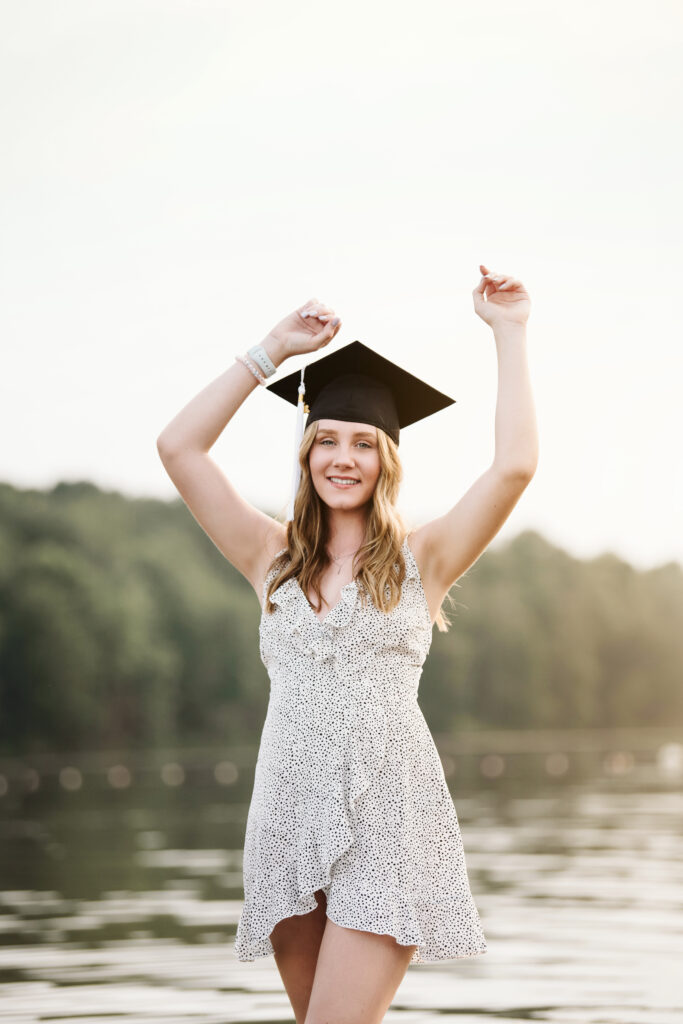 senior girl dances with her graduation cap