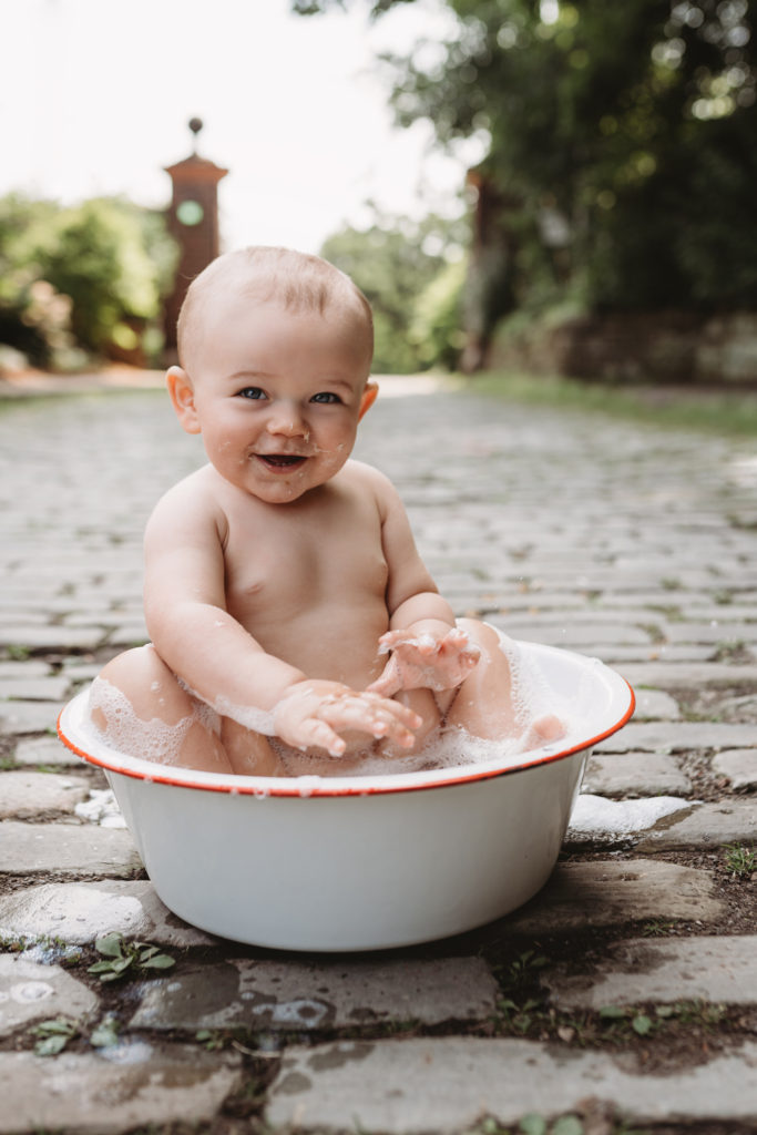 Enjoying a bubble bath after his cake smash photo session. Photo by Laura Mares Photography, Pittsburgh Child Photographer.