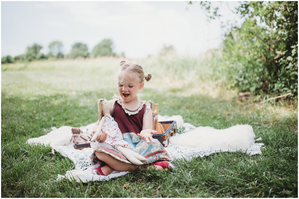 Ella playing with her favorite doll named Tutu. Photo by Laura Mares, a Pittsburgh Child Photographer.