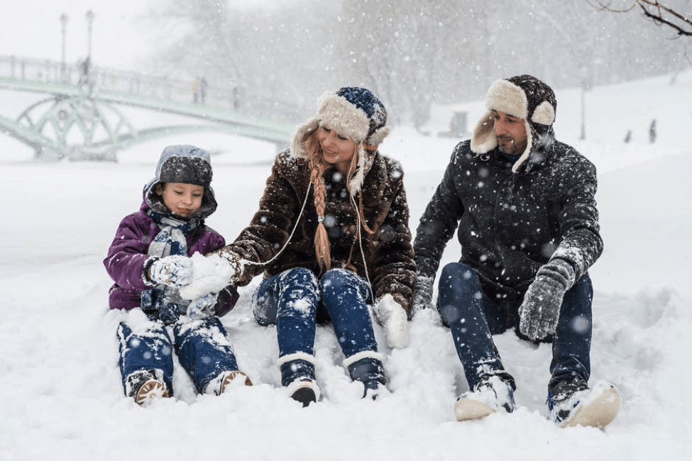 Family stilling together playing with snow.