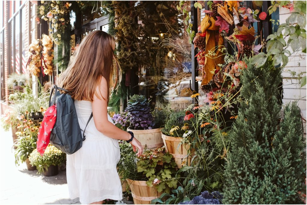 Girl sitting in front of a floral shop. Photo by Laura Mares Photography, Pittsburgh Senior Photographer.