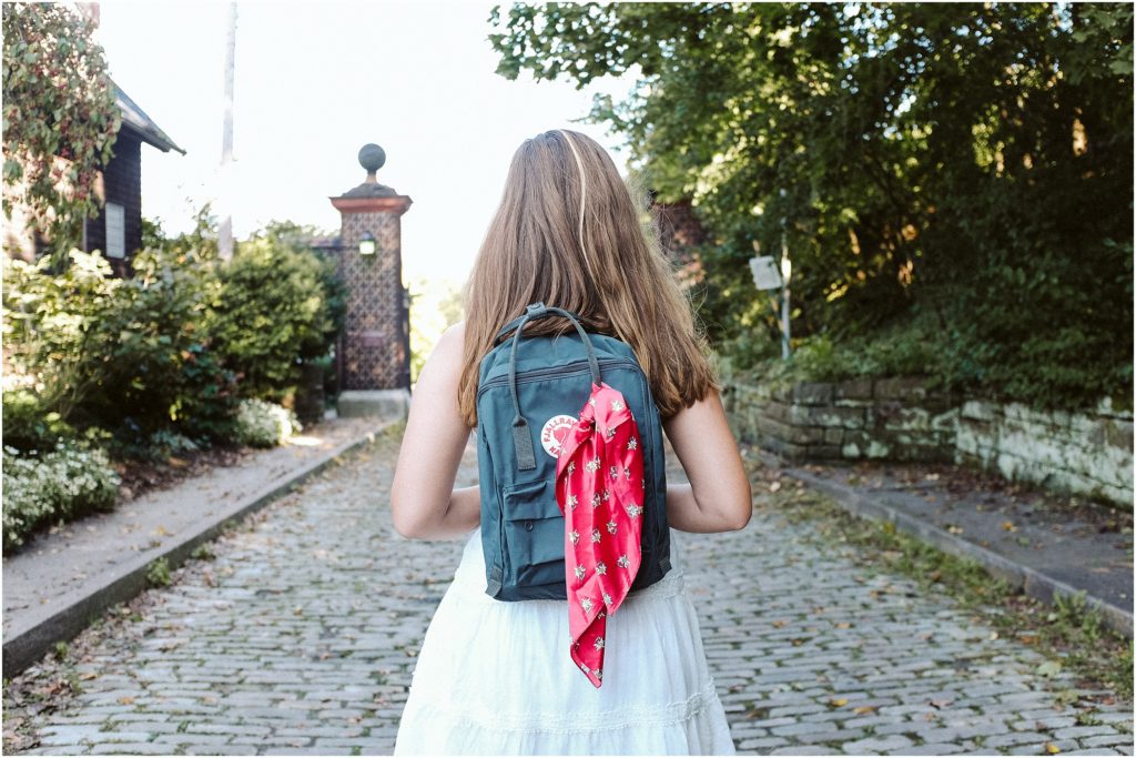 Girl standing on a cobblestone road wearing a fjallraven Kanken backpack. Photo by Laura Mares Photography, Pittsburgh Lifestyle Photographer.