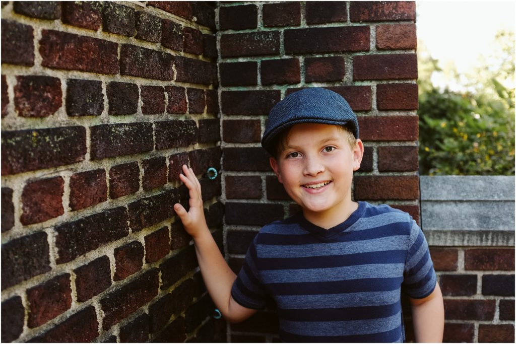 Boy standing in front of a brick wall. Photo by Laura Mares Photography, Pittsburgh Child Photographer.