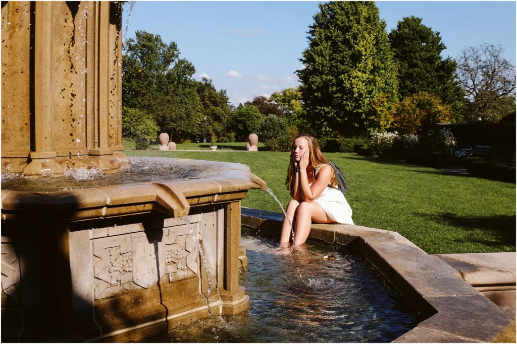 Girl sitting at a fountain in Mellon Park. Photo by Laura Mares Photography, Pittsburgh Senior Photographer.