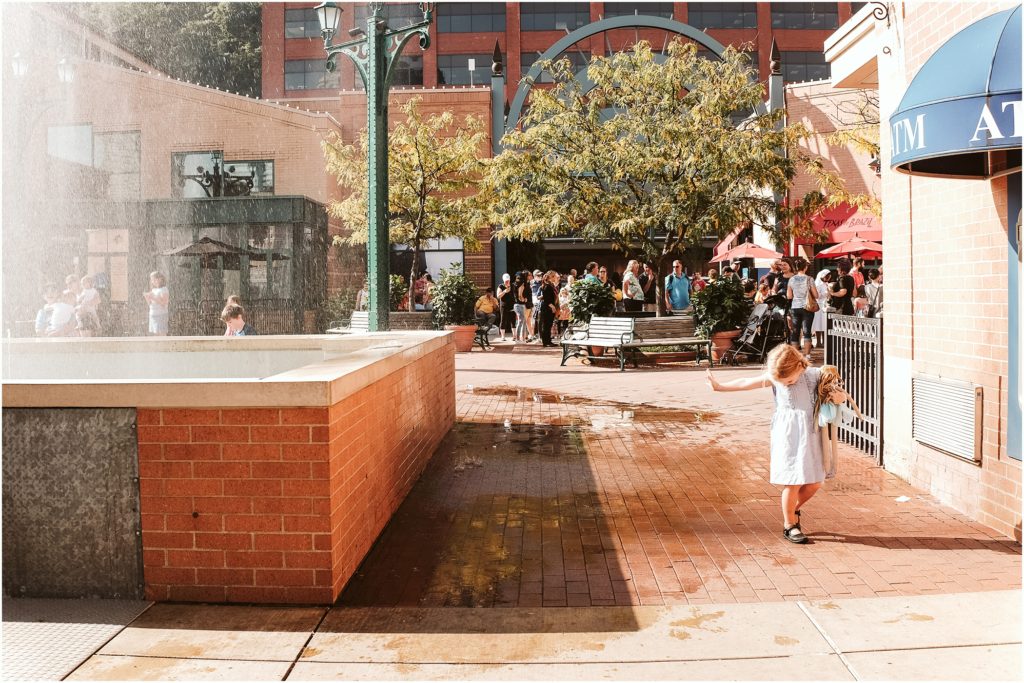 Girl walking near the fountain at Station Square. Photo by Laura Mares Photography, Pittsburgh Child Photographer.