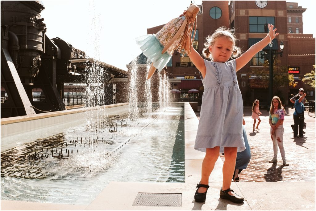 Girl standing on the fountain at Station Square. Photo by Laura Mares Photography, Pittsburgh Child Photographer.