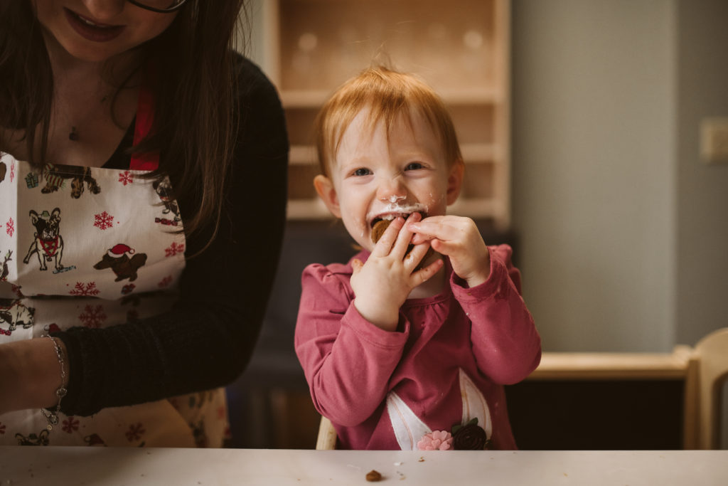 A little girl eating a Christmas cookie. Photo by Laura Mares Photography, Pittsburgh Lifestyle Photographer