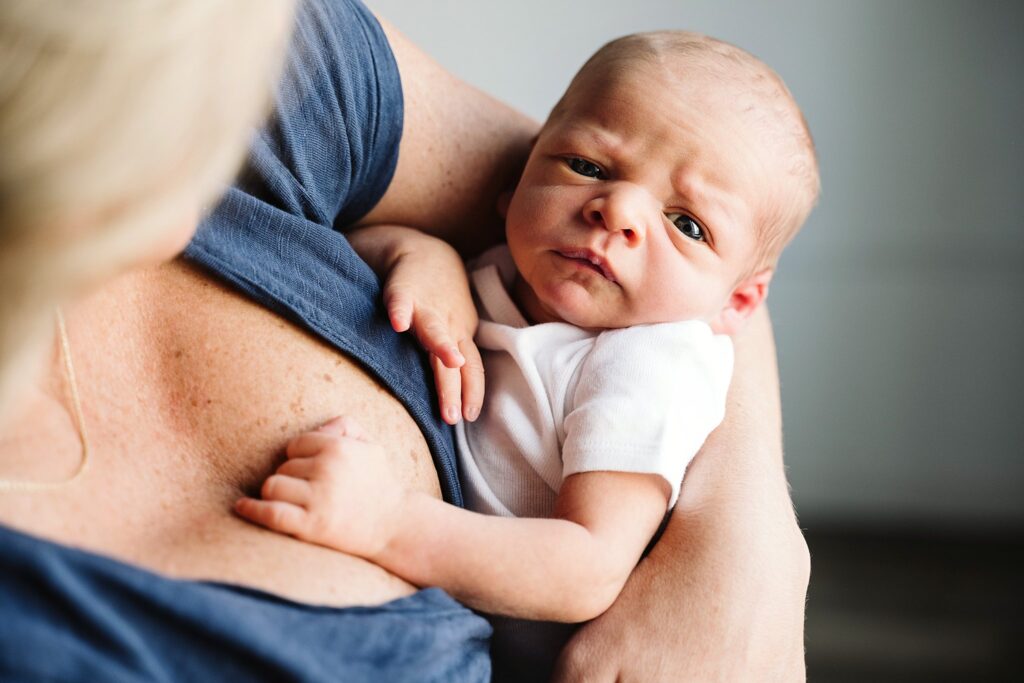 lifestyle portrait of mother holding newborn baby