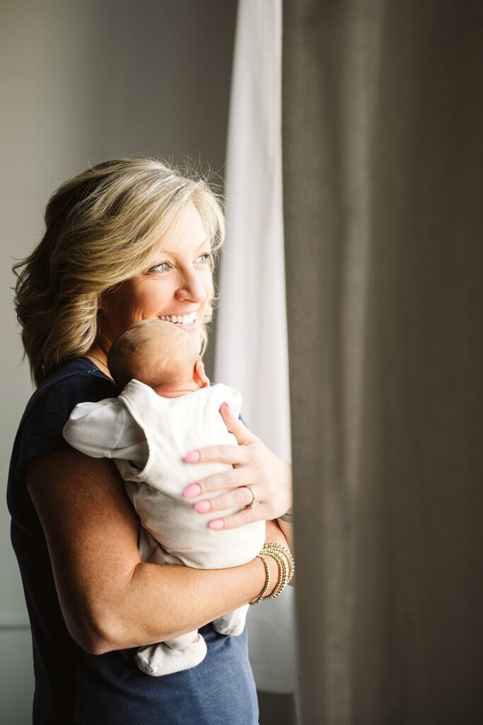 lifestyle portrait of mother holding newborn baby