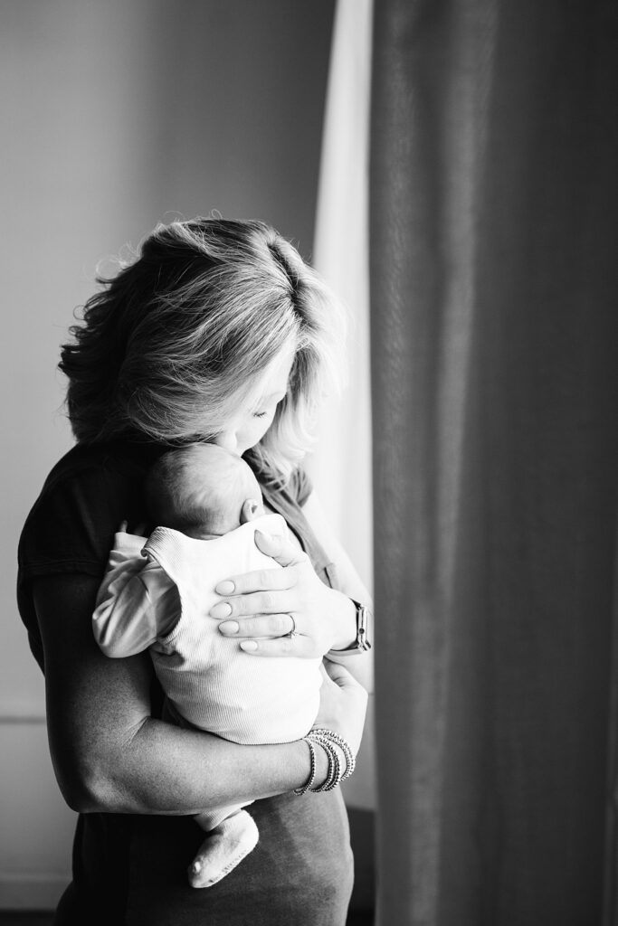 lifestyle portrait of mother holding newborn baby