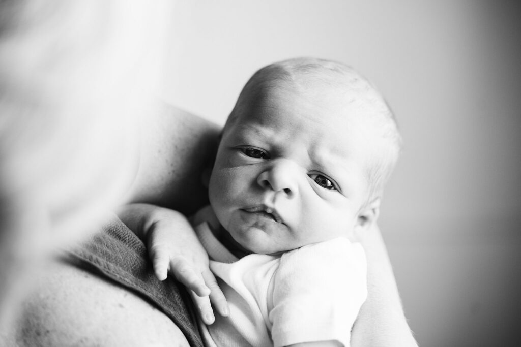 lifestyle portrait of mother holding newborn baby