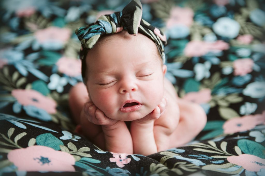 Newborn baby girl posed on a flower blanket. Newborn portrait by Laura Mares Photographer, Pittsburgh Newborn Photographer.