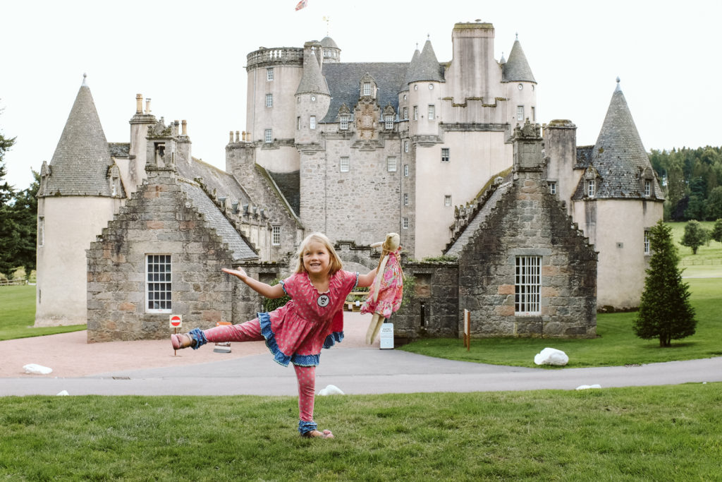Little girl dancing near Castle Fraser in Scotland. Photograph by Laura Mares Photography.
