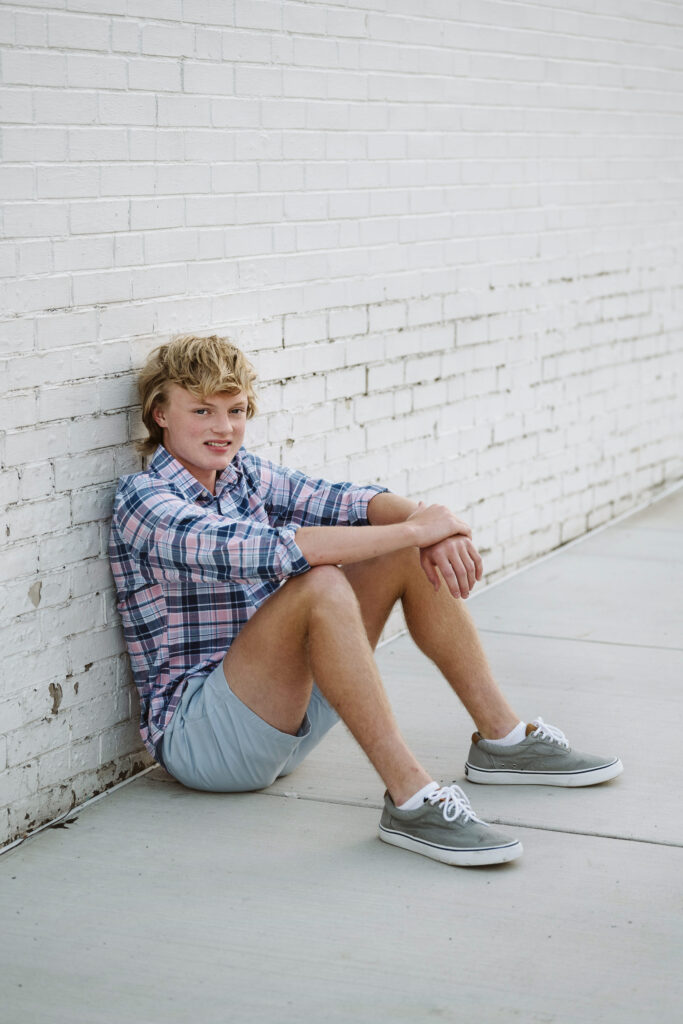 senior guy sitting white wall