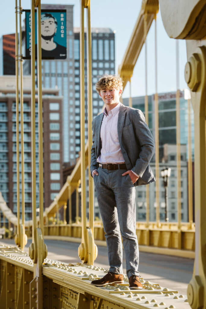 senior guy standing on yellow bridge in Pittsburgh