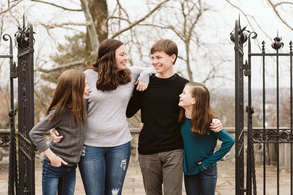 Four siblings laughing together in Mellon Park. Photo by Laura Mares Photography, Pittsburgh Child Photographer.