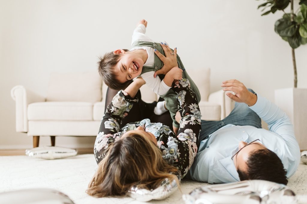 A lifestyle image of a family playing together to celebrate a birthday. Photo by Pittsburgh Newborn Lifestyle Photographer, Laura Mares Photography.
