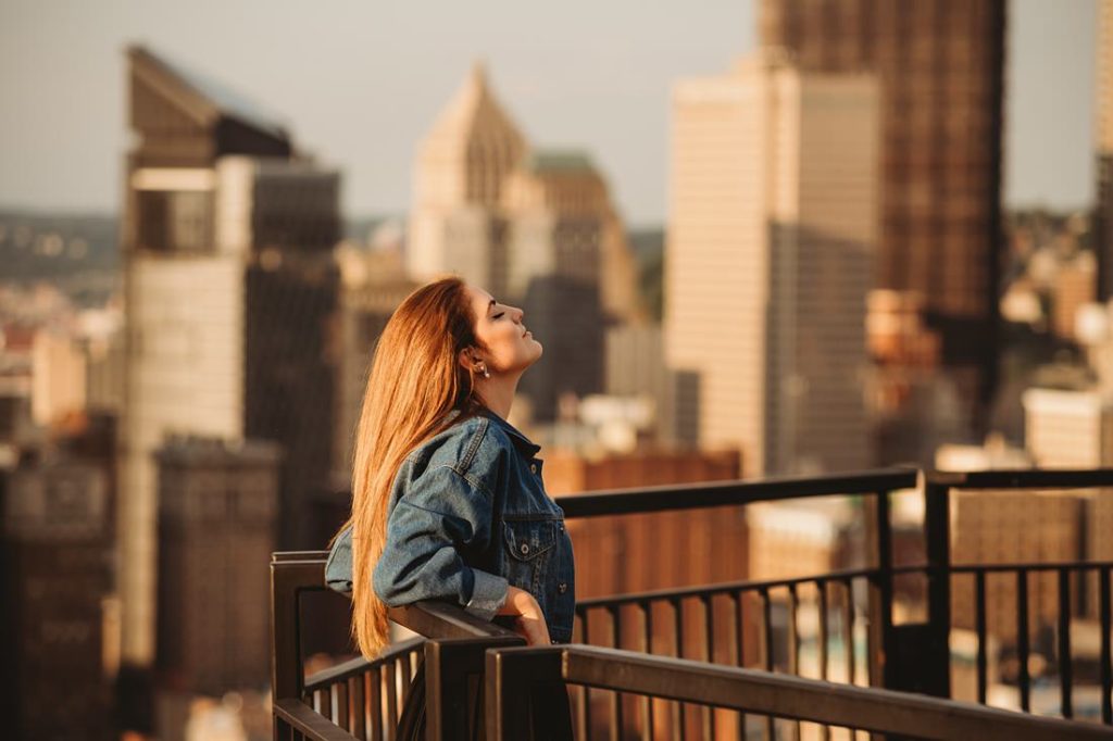 A portrait of a senior girl standing on Mt. Washington at sunset, Pittsburgh. Portrait by Laura Mares Photography, Pittsburgh Senior Photographer