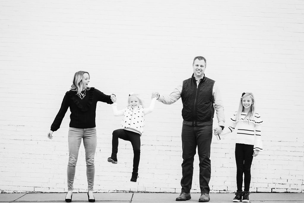 Black and white Urban Family Portrait with white brick wall. Portrait taken by Laura Mares Photography, Pittsburgh Family Photographer.