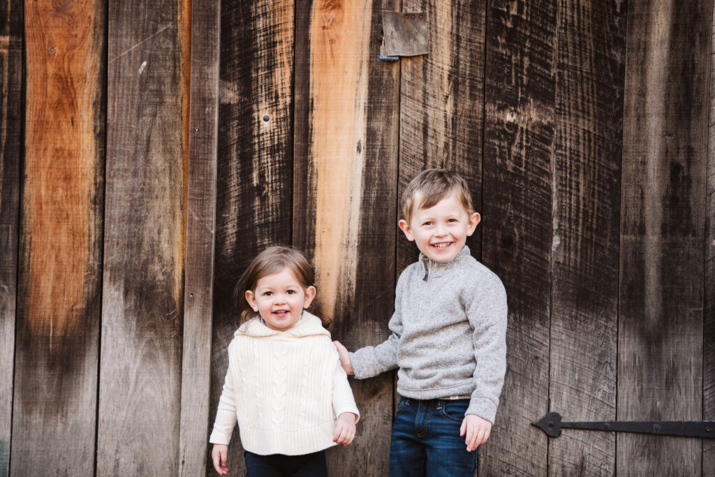 children holding hands in front of a wooden background