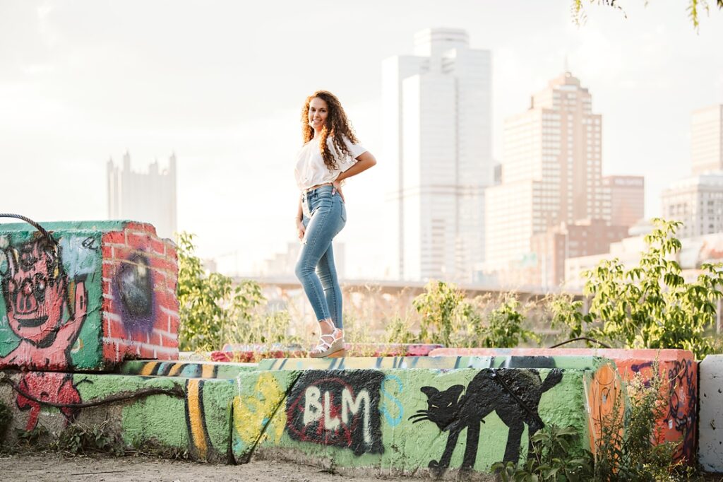 High school senior girl posing for senior photos in color park in downtown Pittsburgh