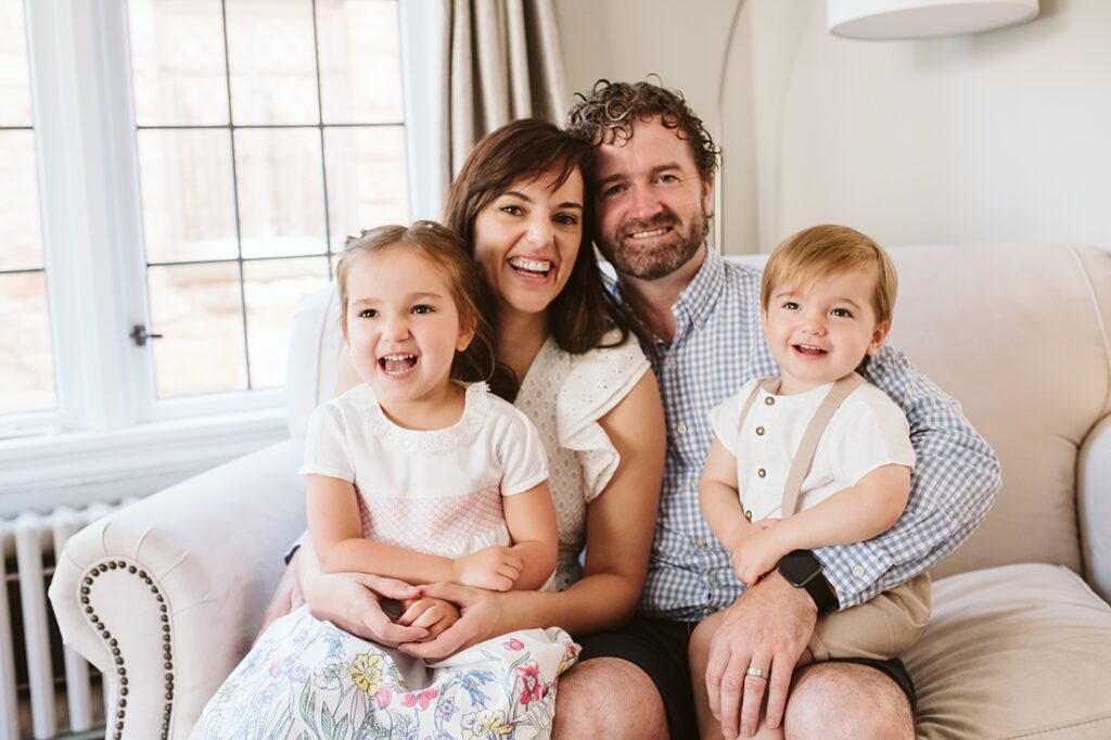 Lifestyle portrait of a family sitting together in their living room.