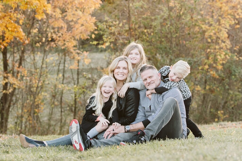 a family of five sitting on a field together