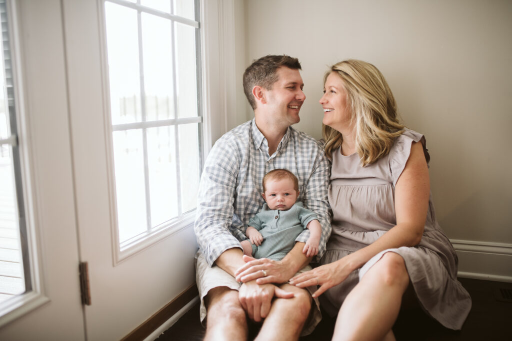 at home picture of parents holding their newborn baby