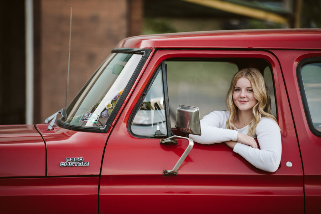 portrait of a senior girl sitting in a red ford truck near Pittsburgh, PA