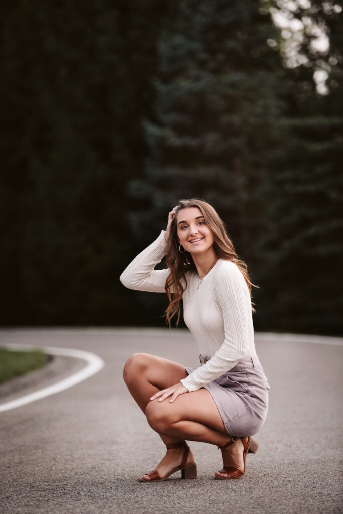 portrait of a high school senior posing for senior pictures on a curving road near Pittsburgh, PA
