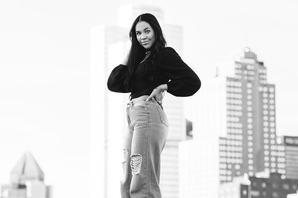 black and white picture of a senior girl with Pittsburgh's skyscrapers in the background