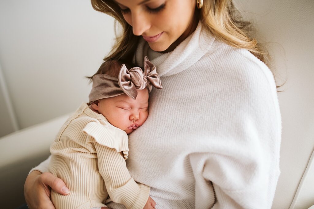 Close up lifestyle portrait of mother holding baby girl in white nursery near Pittsburgh, PA