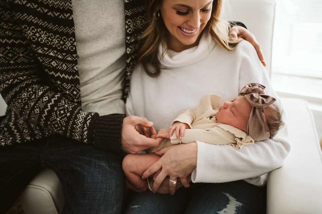 Close up lifestyle portrait of parents holding baby girl in white nursery near Pittsburgh, PA