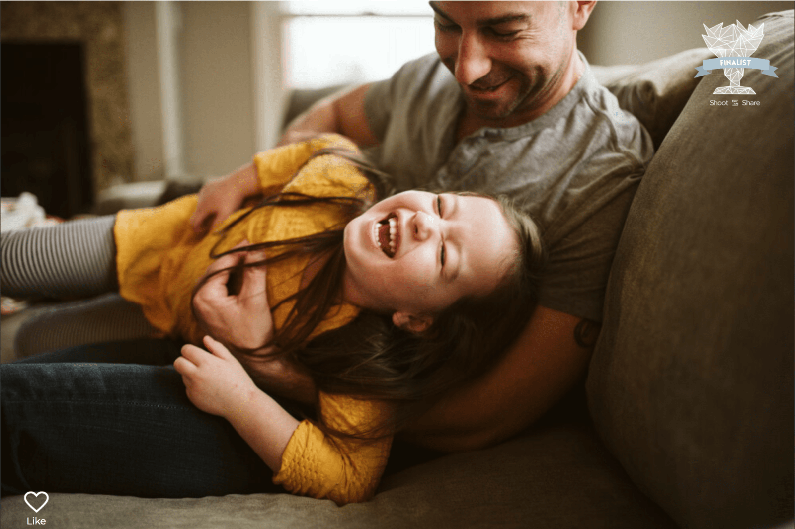 lifestyle picture of a dad laughing with his daughter on the living room sofa. Photo taken by Laura Mares Photography, Pittsburgh Photographer.