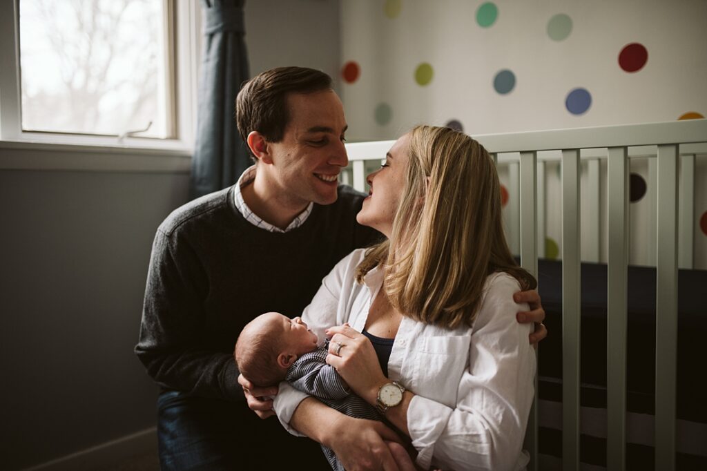 lifestyle image of parents holding their baby in the nursery
