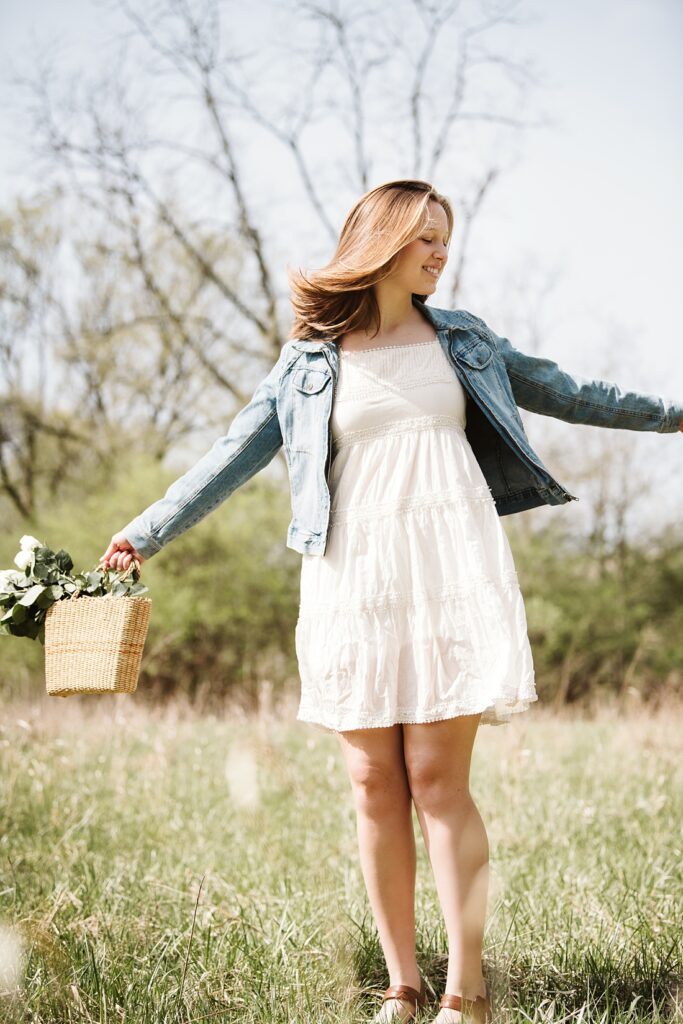 senior girl dancing in a field at frick park in Pittsburgh