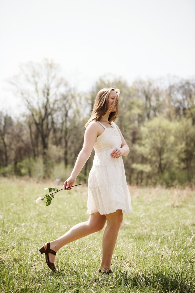 senior pictures of a girl walking through a field in Pittsburgh's Frick Park