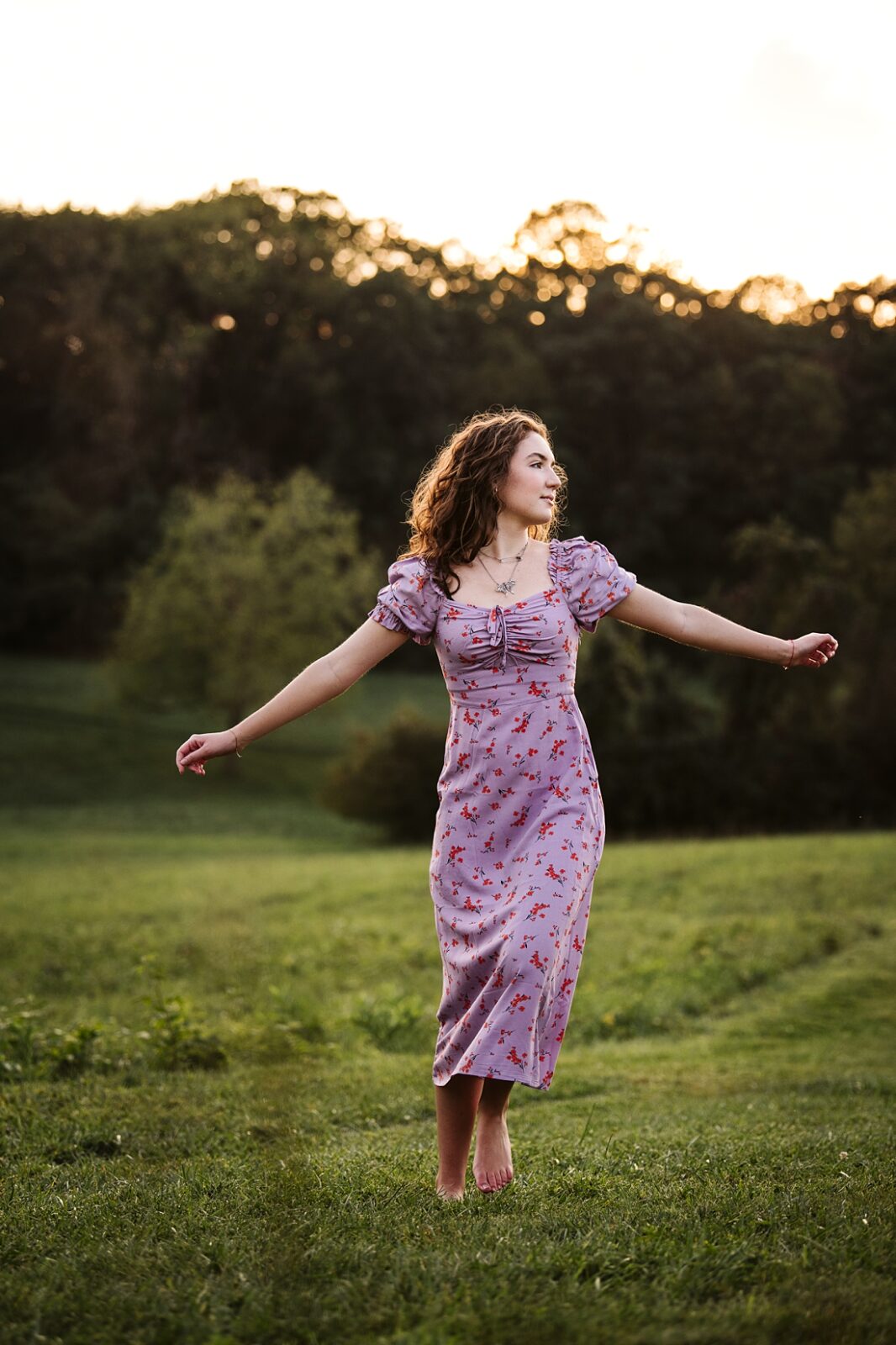 senior girl dancing on a rustic field at sunset near Pittsburgh