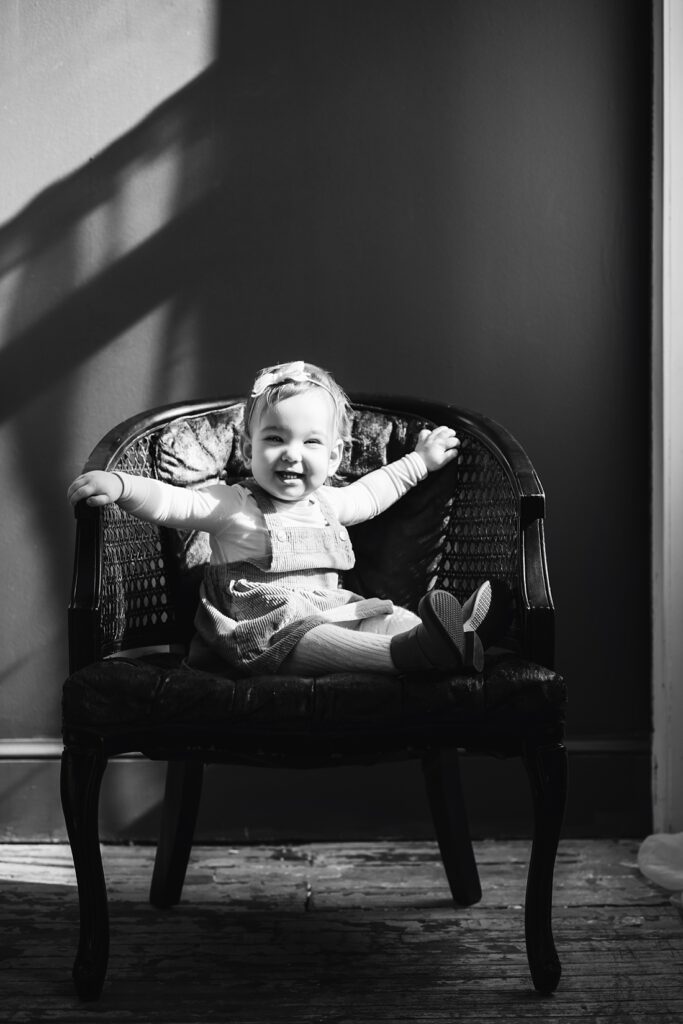 first birthday portrait of baby girl sitting on a chair 