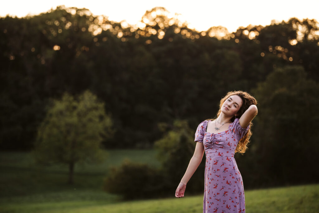 portrait of senior girl walking on a field at sunset near Pittsburgh, PA