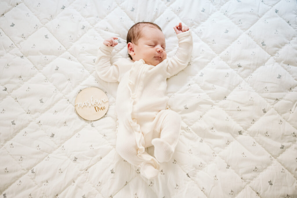 newborn lifestyle photograph of baby laying on white blanket