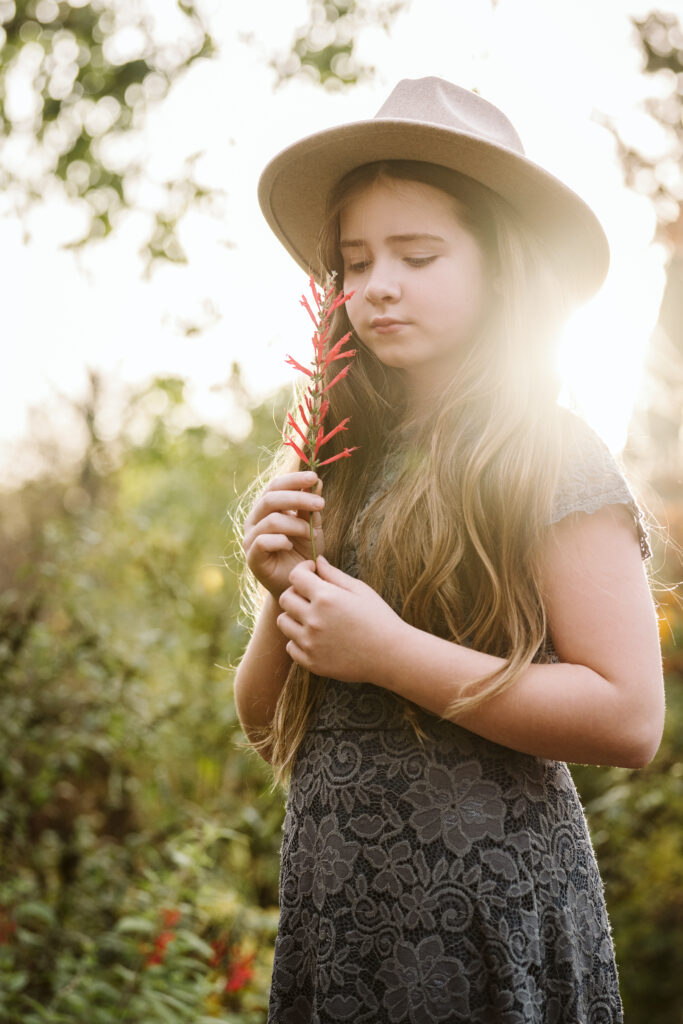 golden hour portrait of a girl holding a flower in Pittsburgh's Mellon Park