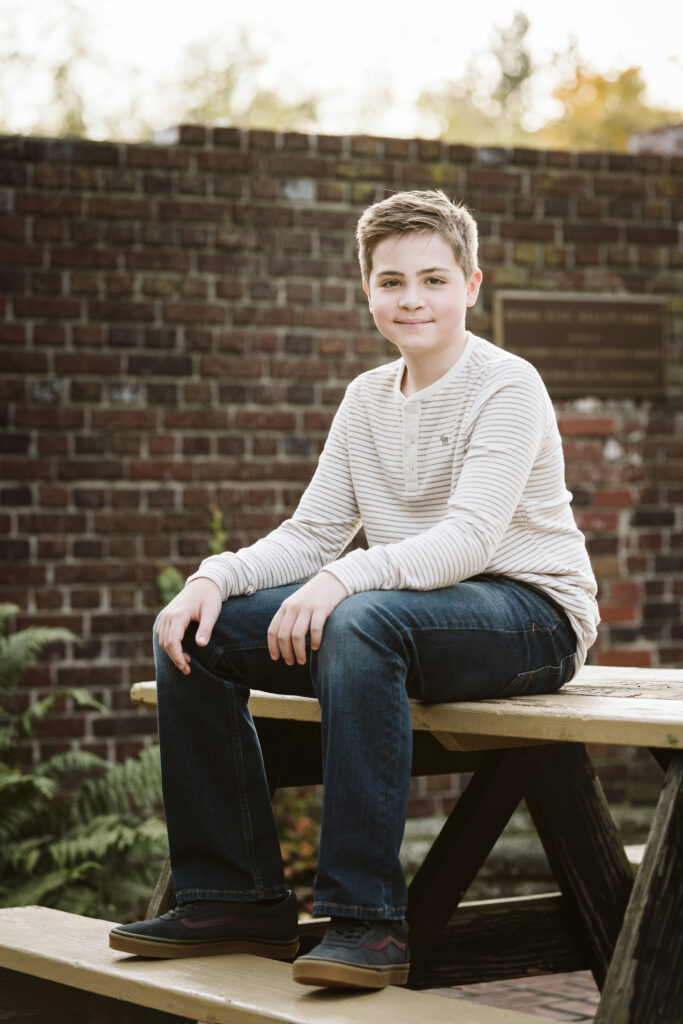 son sitting on a picnic table during a portrait session in Pittsburgh's Mellon Park