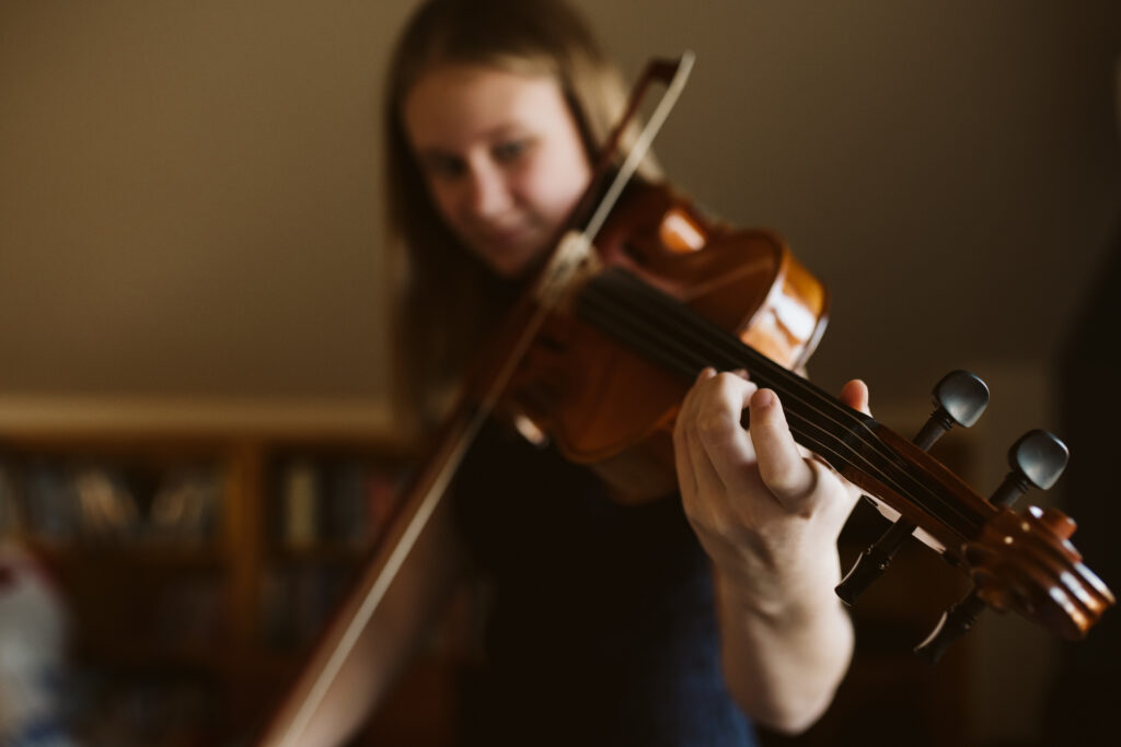 Teenager playing viola at home